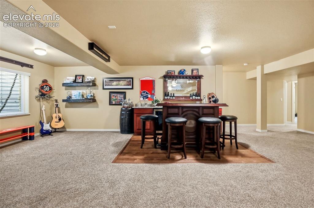 Image 27 of 41: Built in wet bar, stainless steel sink and beverage cooler/mini fridge. Her