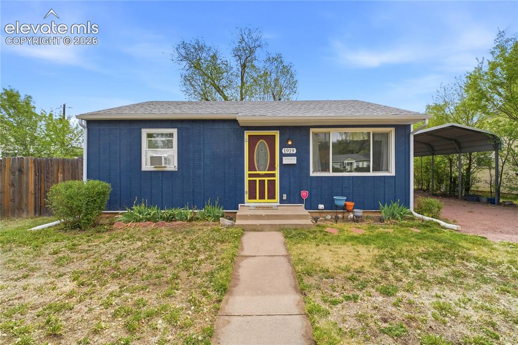 Caption: Blue exterior with white trim, a yellow-framed screen door, and a gray shingle roof