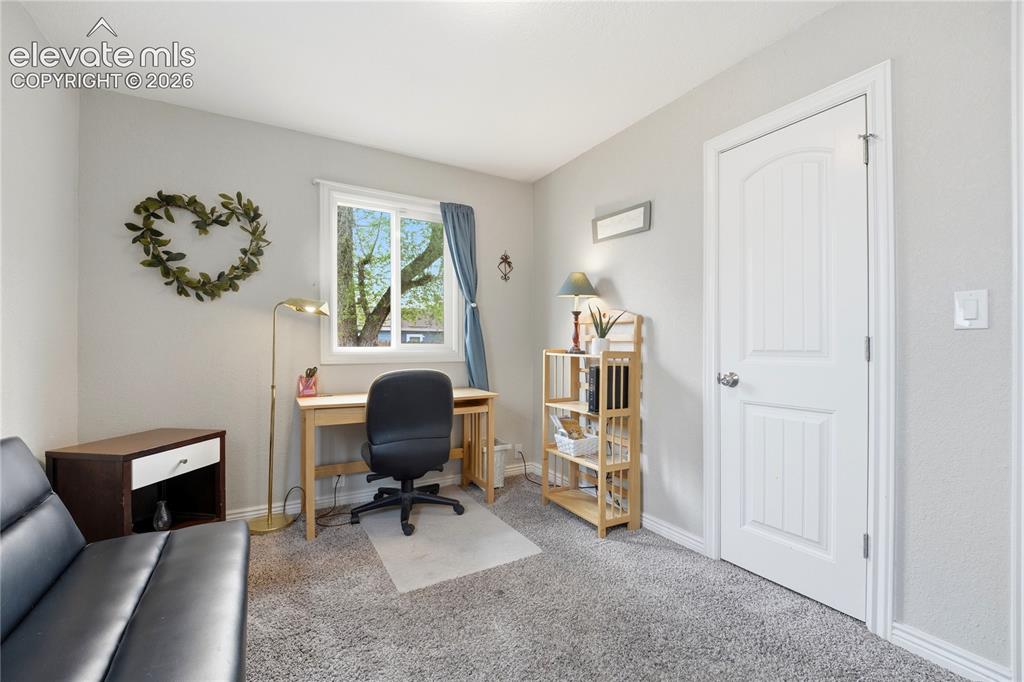 Image 10 of 22: Carpeted flooring, white trim, and a white interior door