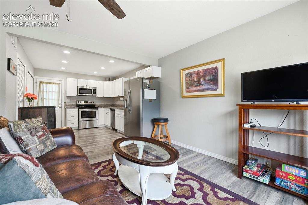 Image 5 of 22: Open-concept living area with wood-finish flooring, recessed lighting, and 