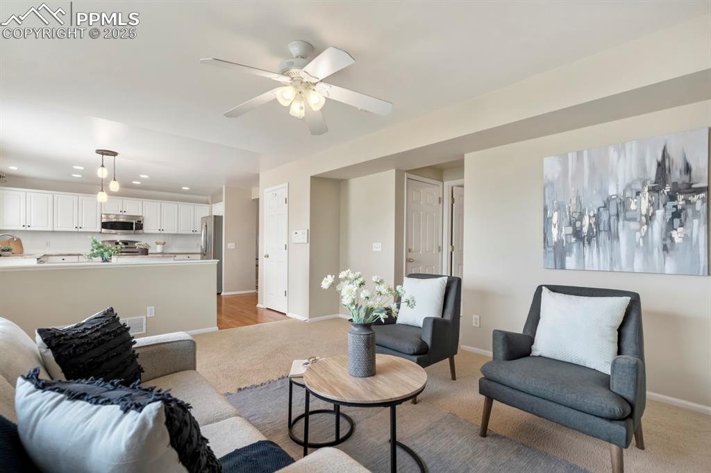Image 11 of 24: Living room with light colored carpet, recessed lighting, and a ceiling fan