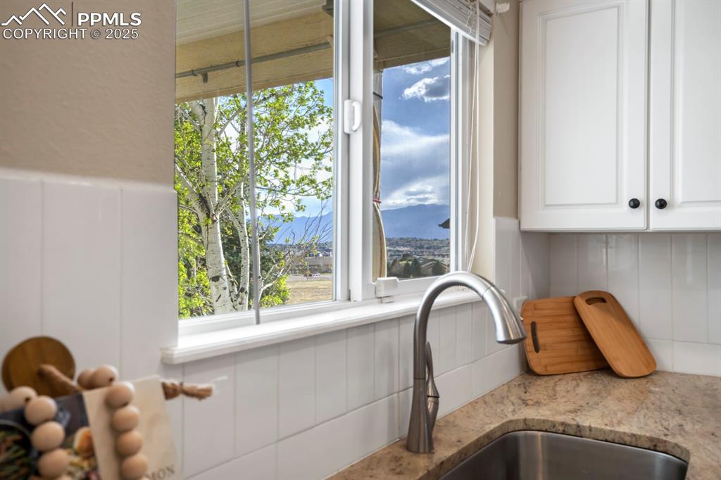 Image 4 of 24: Kitchen view of white cabinetry and light stone countertops