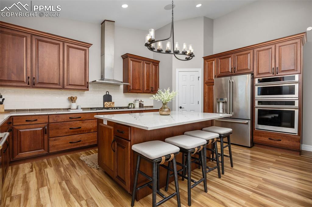 Image 12 of 49: The kitchen features rich wood cabinetry, a large center island with a whit