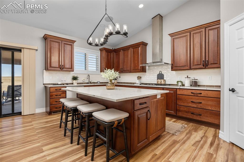Image 13 of 49: The kitchen features wood cabinetry, a central island with a light-colored 