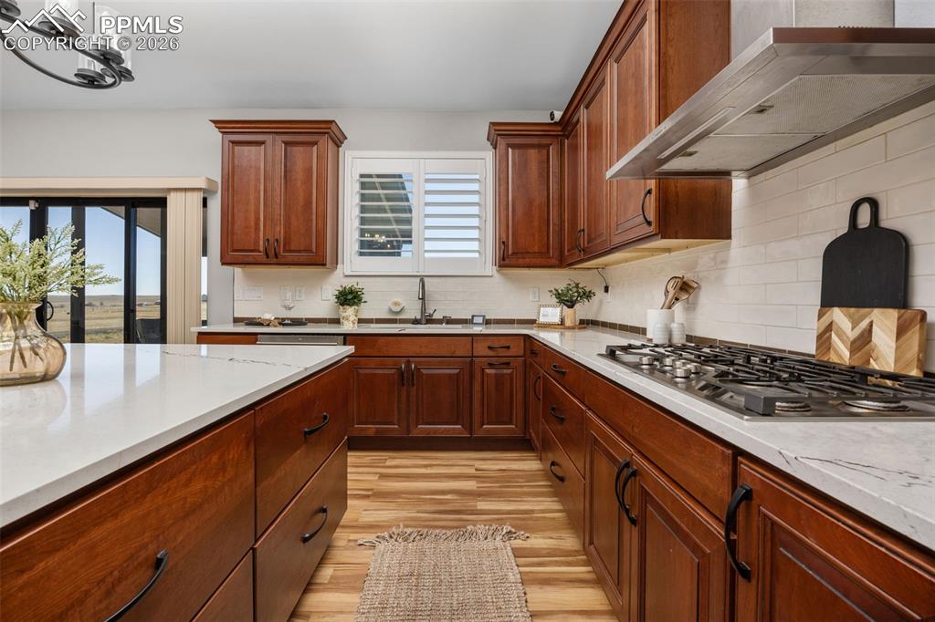 Image 14 of 49: The kitchen features rich wood cabinetry, light-colored countertops, a gas 