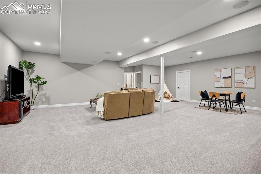 Image 25 of 49: Spacious entertainment area featuring light gray carpeting, recessed lighti