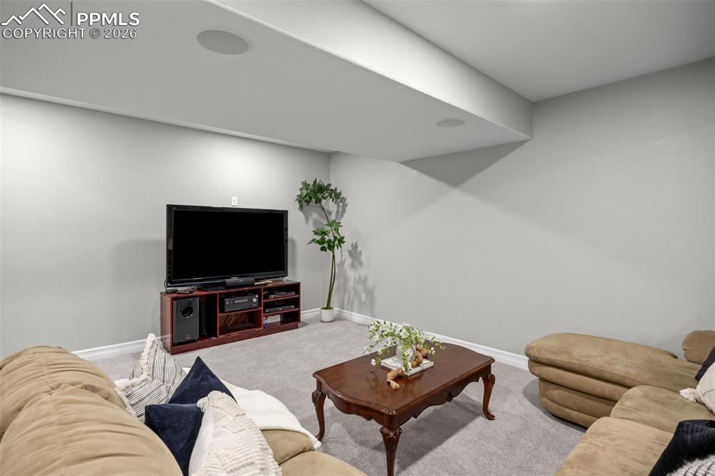 Image 26 of 49: This living space features soft grey walls, light grey carpeting, and reces