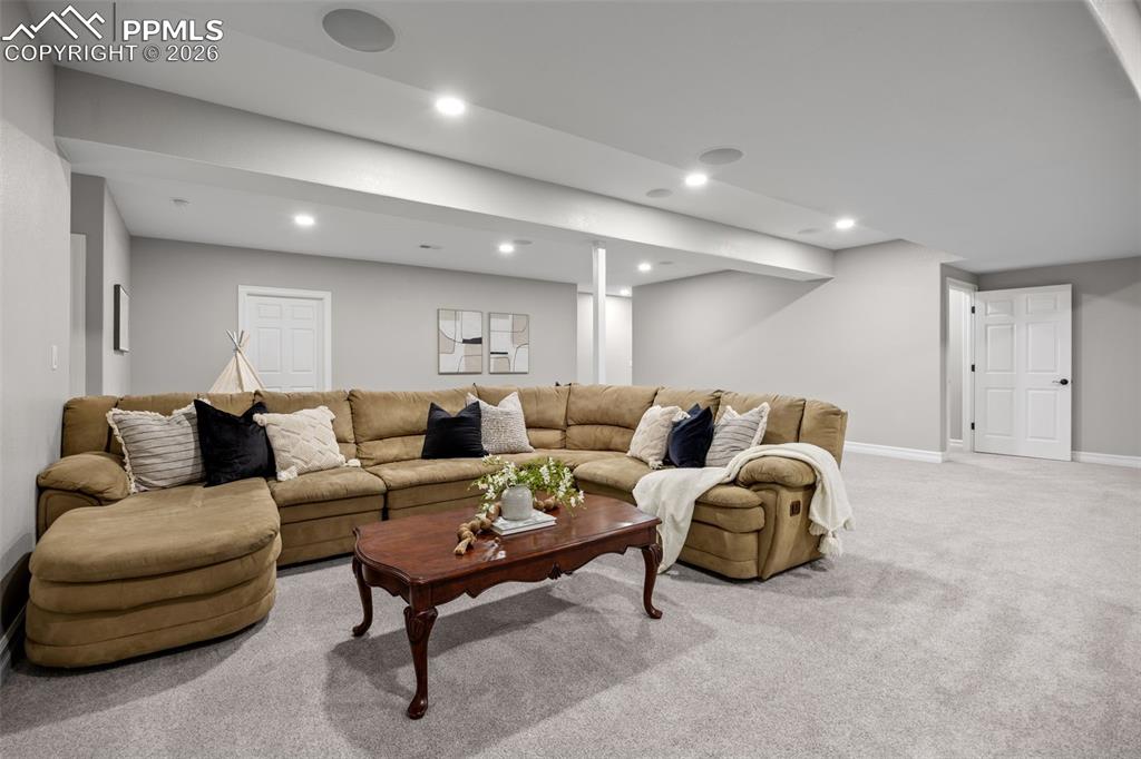 Image 27 of 49: Spacious living area featuring light gray walls, recessed lighting, and lig