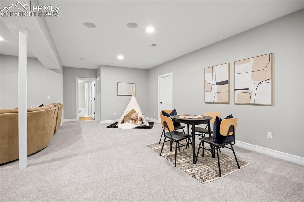 Image 29 of 49: Spacious room featuring light gray walls, light colored carpeting, recessed