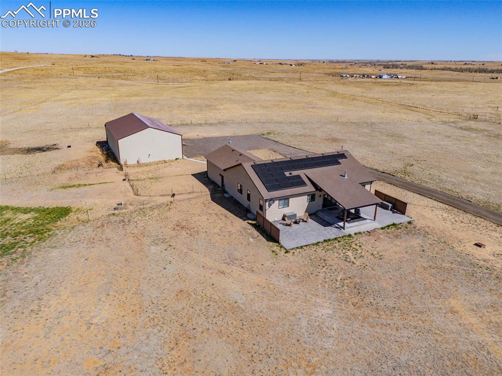 Image 40 of 49: The property features a single-story dwelling with a large flat roof sectio