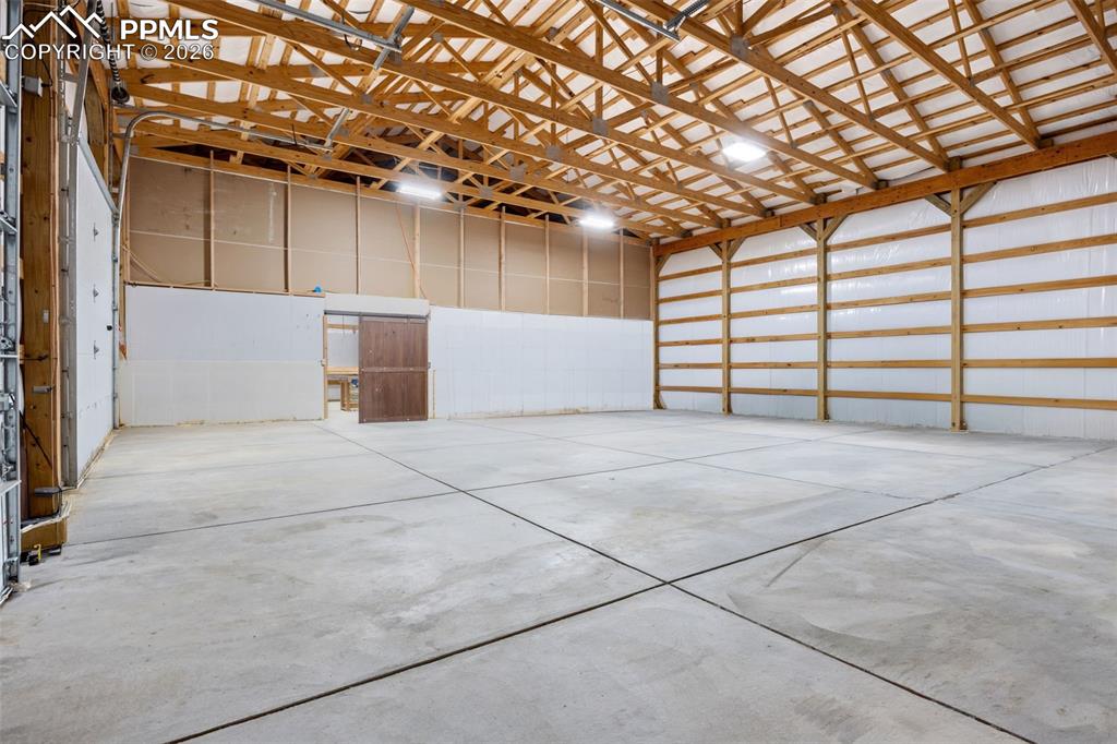 Image 44 of 49: The property features an expansive open space with a concrete floor, expose