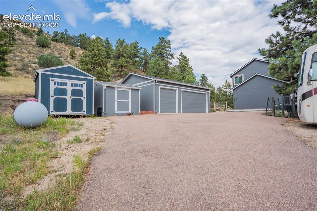 Image 11 of 47: 24x30 3 car garage plus two smaller sheds perfect for storage and overflow 