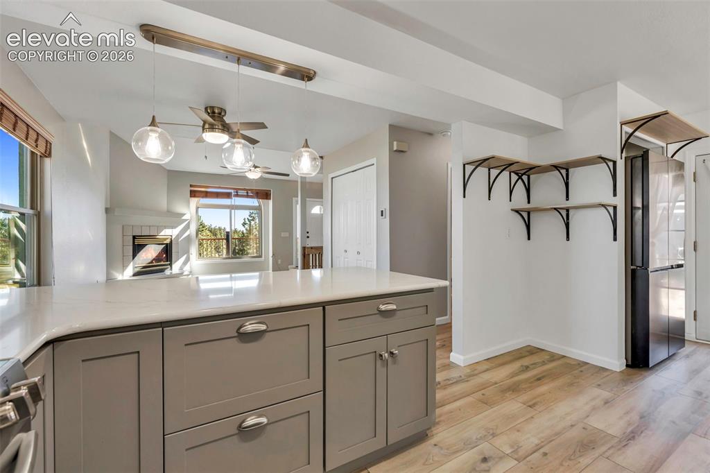 Image 23 of 47: Kitchen is all new with decorative light fixtures, white granite countertop