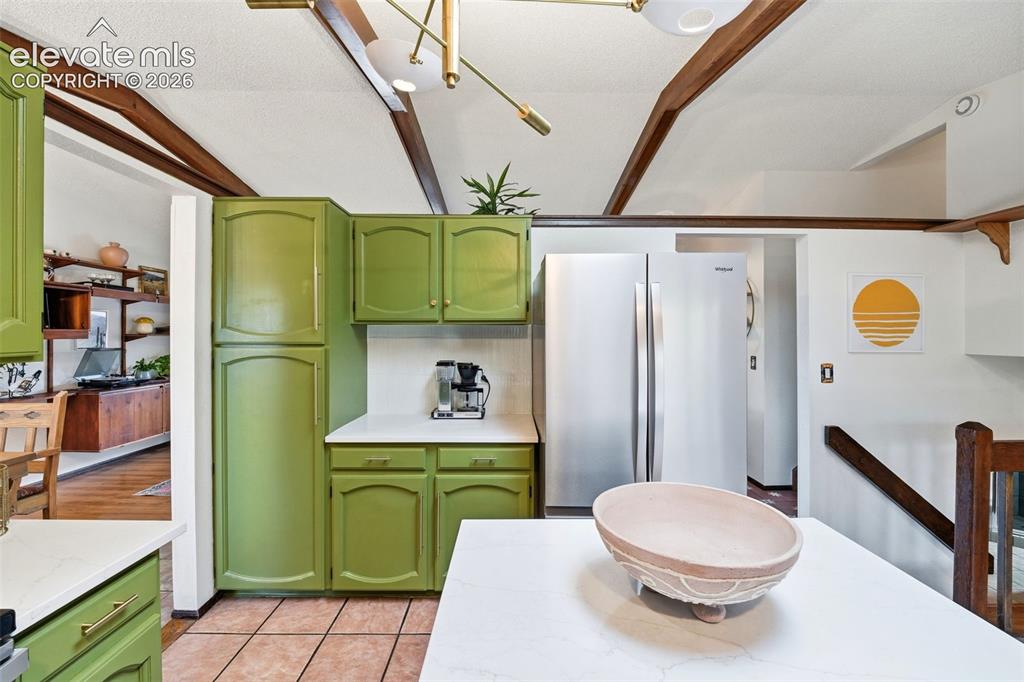 Image 12 of 42: Kitchen featuring green cabinetry, white countertops, tile flooring, and a 