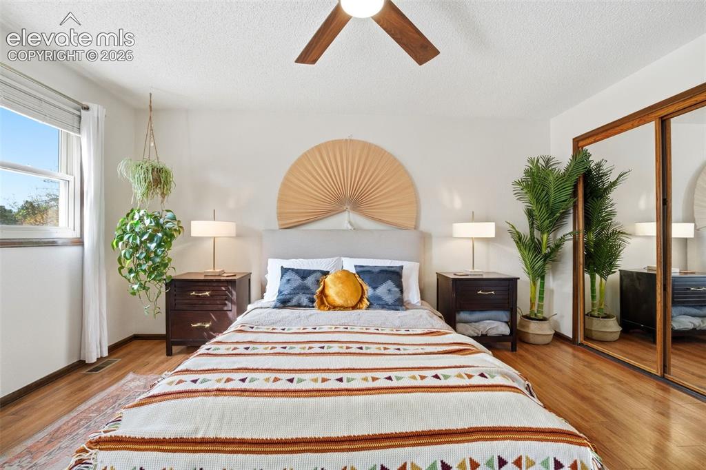 Image 15 of 42: Bedroom featuring wood-finish flooring, a ceiling fan with wood-finish blad