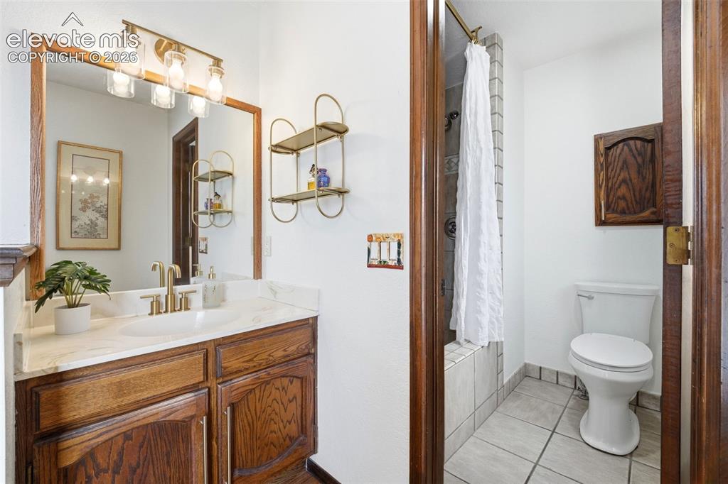 Image 16 of 42: Bathroom vanity featuring a wood-finish cabinet, a white countertop, and a 