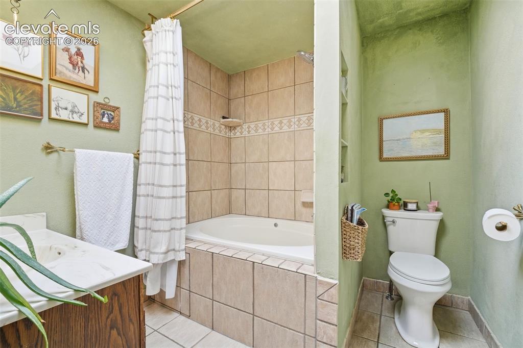 Image 22 of 42: Bathroom featuring a tiled shower-over-tub combination with an accent borde