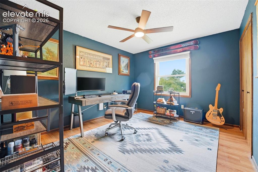 Image 23 of 42: Room featuring wood-finish flooring, a ceiling fan with integrated lighting