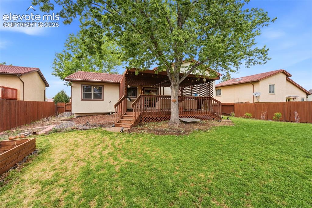 Image 32 of 42: Expansive backyard featuring a lush lawn, raised garden bed, and a sizable 