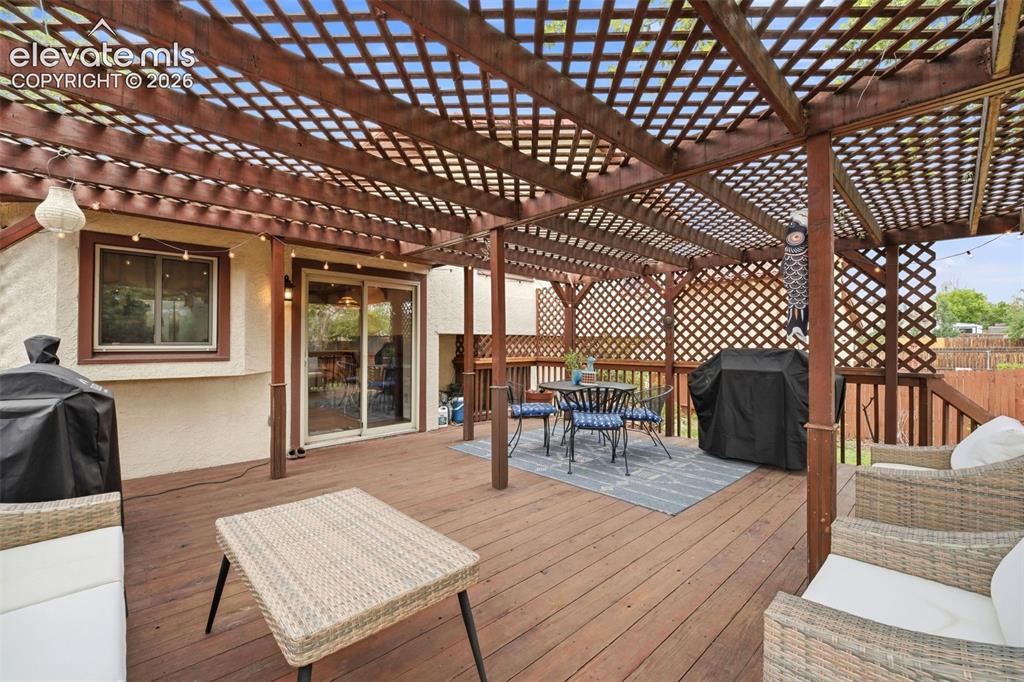 Image 33 of 42: Expansive wood-finish deck featuring a lattice-style pergola