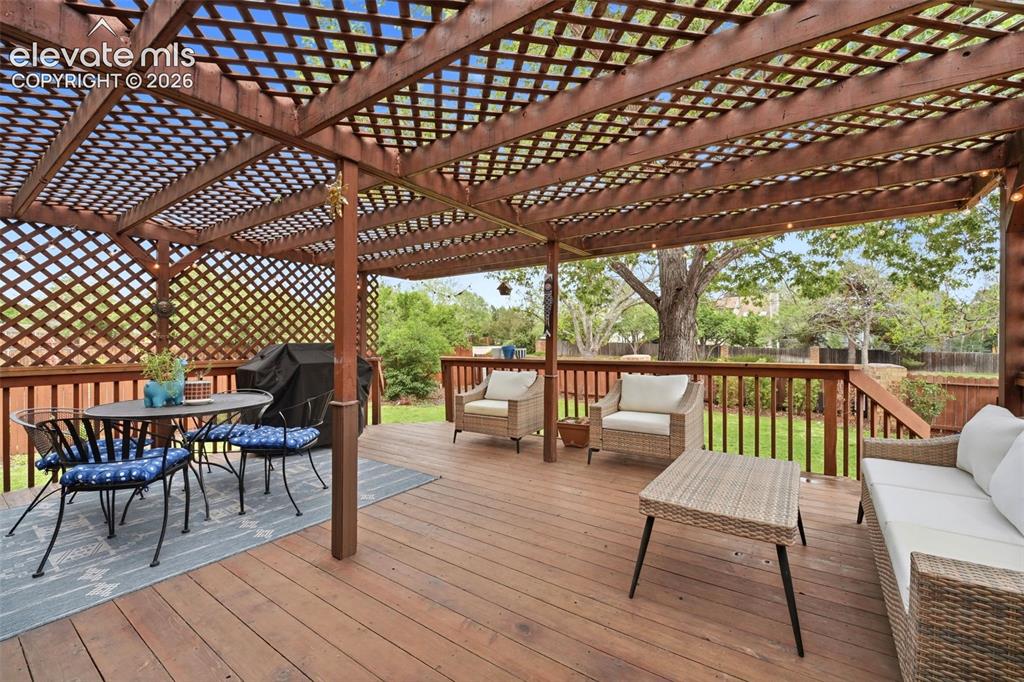 Image 35 of 42: Expansive wood-finish deck featuring a lattice pergola and full perimeter r
