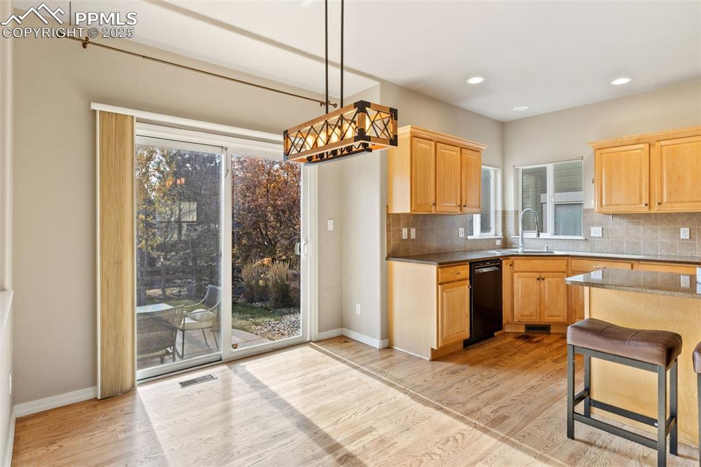 Image 10 of 34: The informal dining area leads to the beautiful outdoor space.