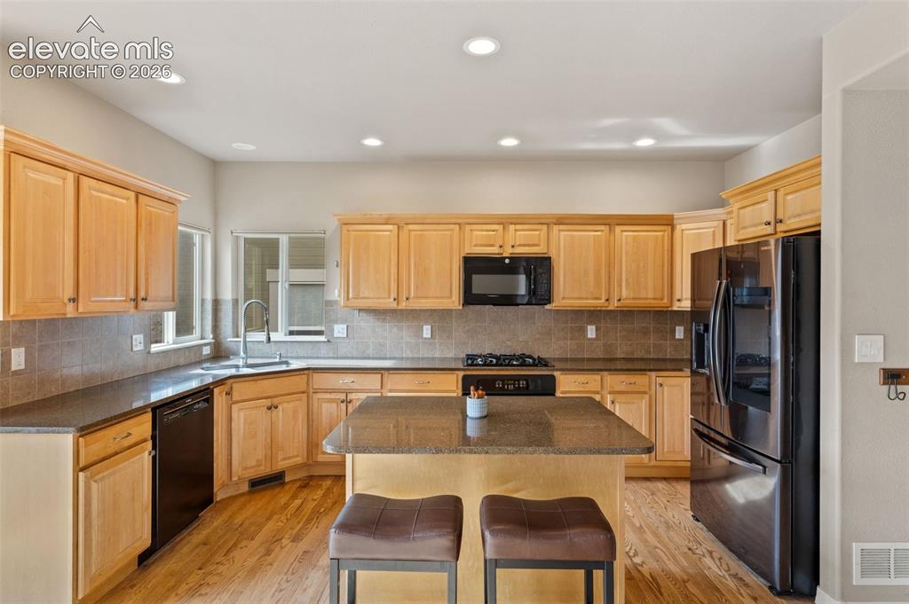 Image 10 of 36: The warm, inviting kitchen features so much counter space and oak cabinet s