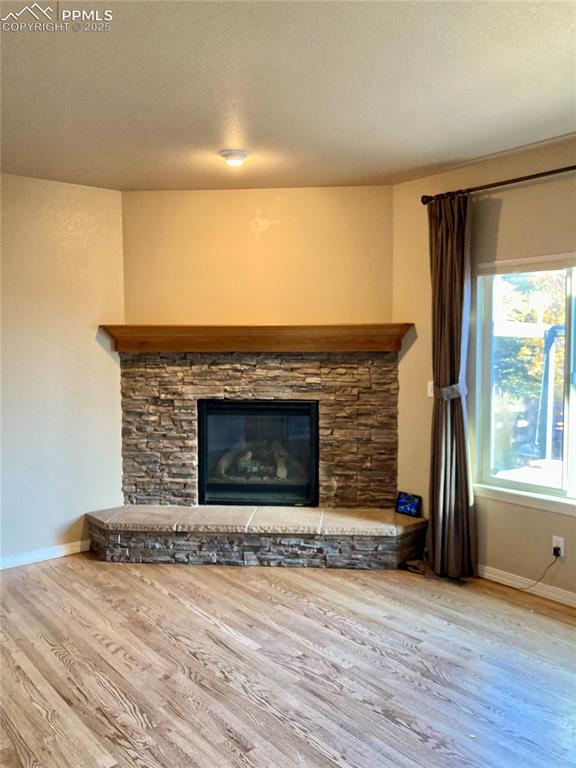 Image 18 of 36: The focal point of the living room is an attractive gas fireplace with ston