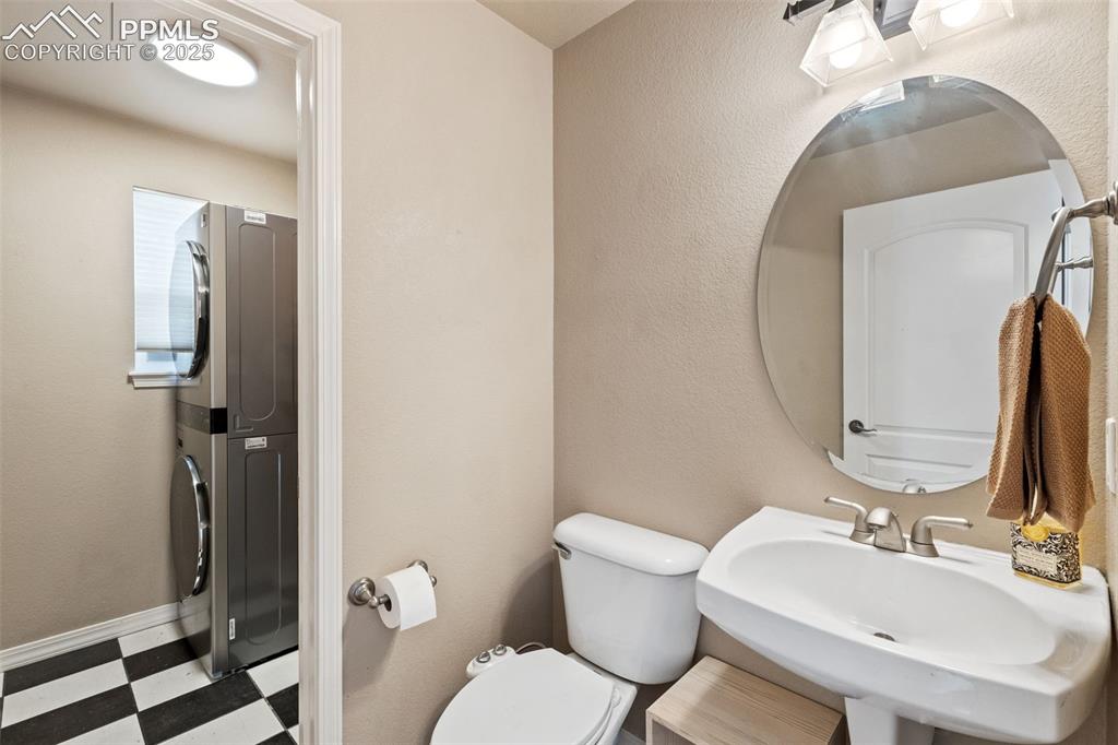Image 20 of 36: The powder room and adjacent laundry area are at the garage entry. The newe