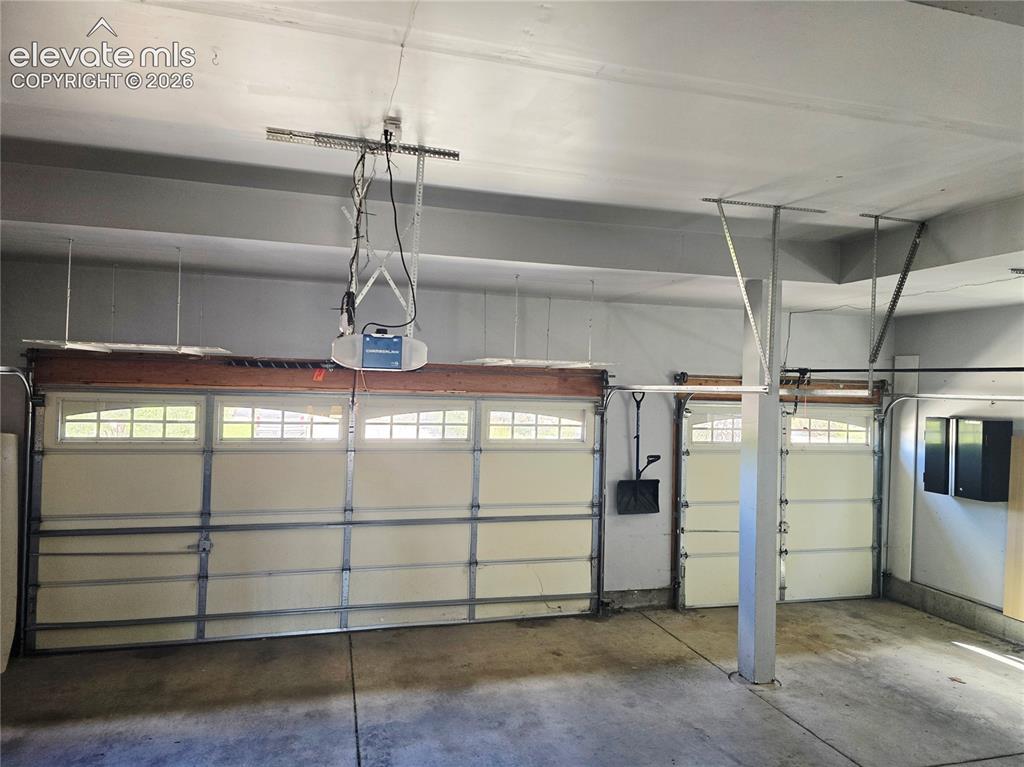 Image 36 of 36: Spacious 3-car garage boasts high ceilings, built-in cabinets and shelves, 