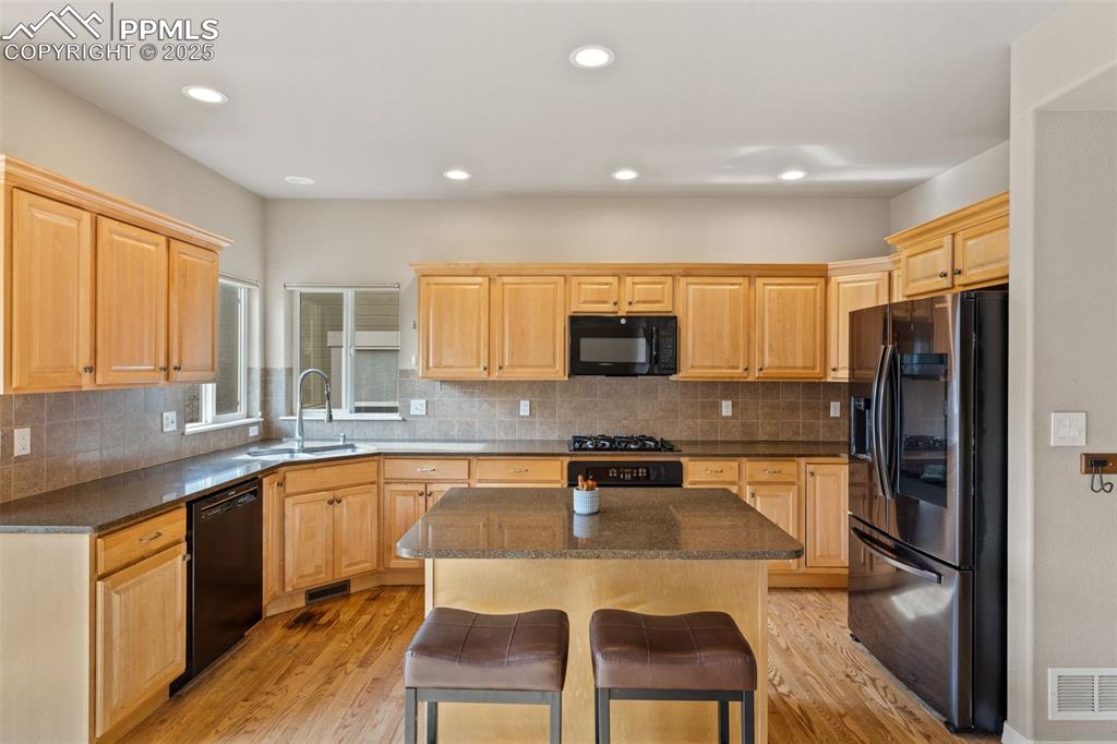 Image 9 of 34: The warm, inviting kitchen features so much counter space and oak cabinet s