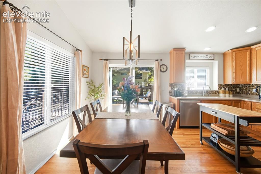 Image 15 of 50: Wood-finish flooring throughout, with a dining area featuring a linear chan