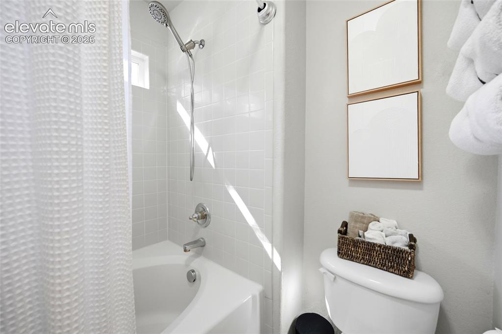 Image 26 of 50: White subway tile shower surround with a built-in tub, chrome fixtures, and