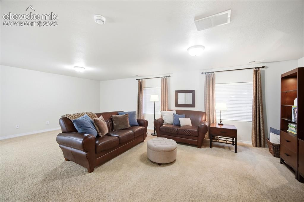 Image 31 of 50: Recessed lighting, light beige carpeting, white walls, and window treatment