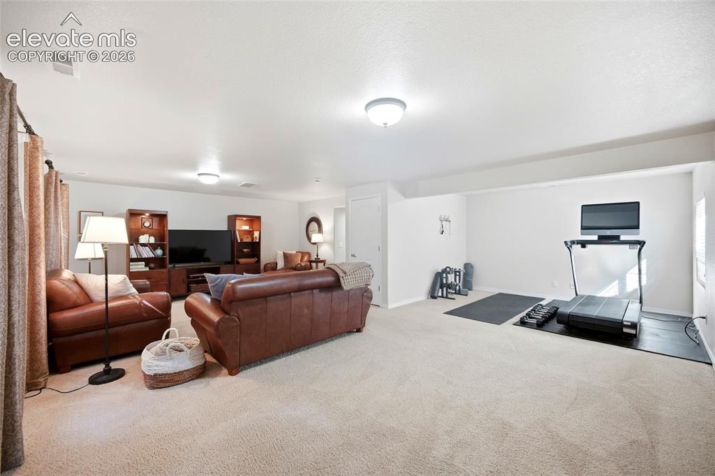 Image 35 of 50: Recessed lighting illuminates this expansive carpeted room with distinct ac