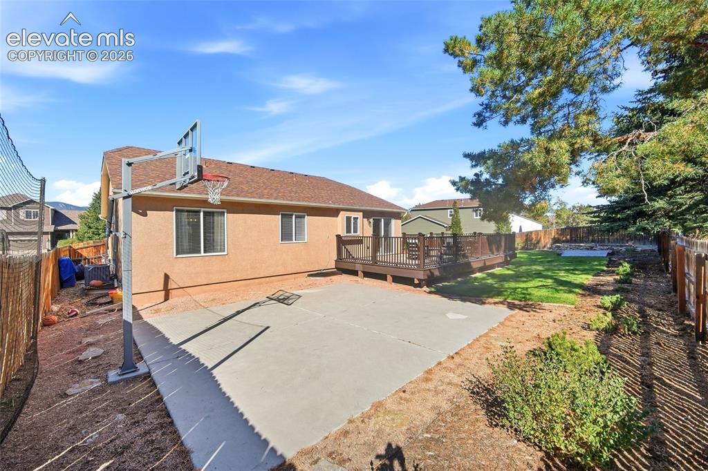 Image 39 of 50: Expansive backyard featuring a large concrete patio, a multi-level wood dec