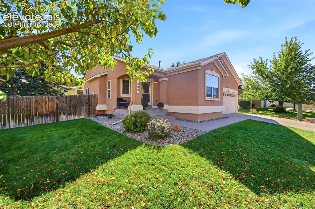 Image 4 of 50: Stucco exterior with a covered front entry, attached garage, concrete drive