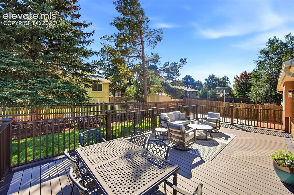 Image 41 of 50: Expansive outdoor deck with composite decking, dark railings, and a privacy