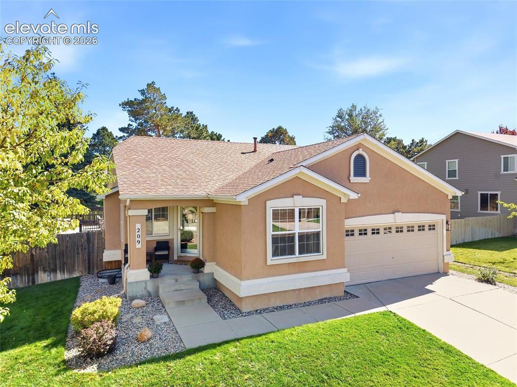 Image 42 of 50: Stucco exterior with arched window accent, attached two-car garage, concret