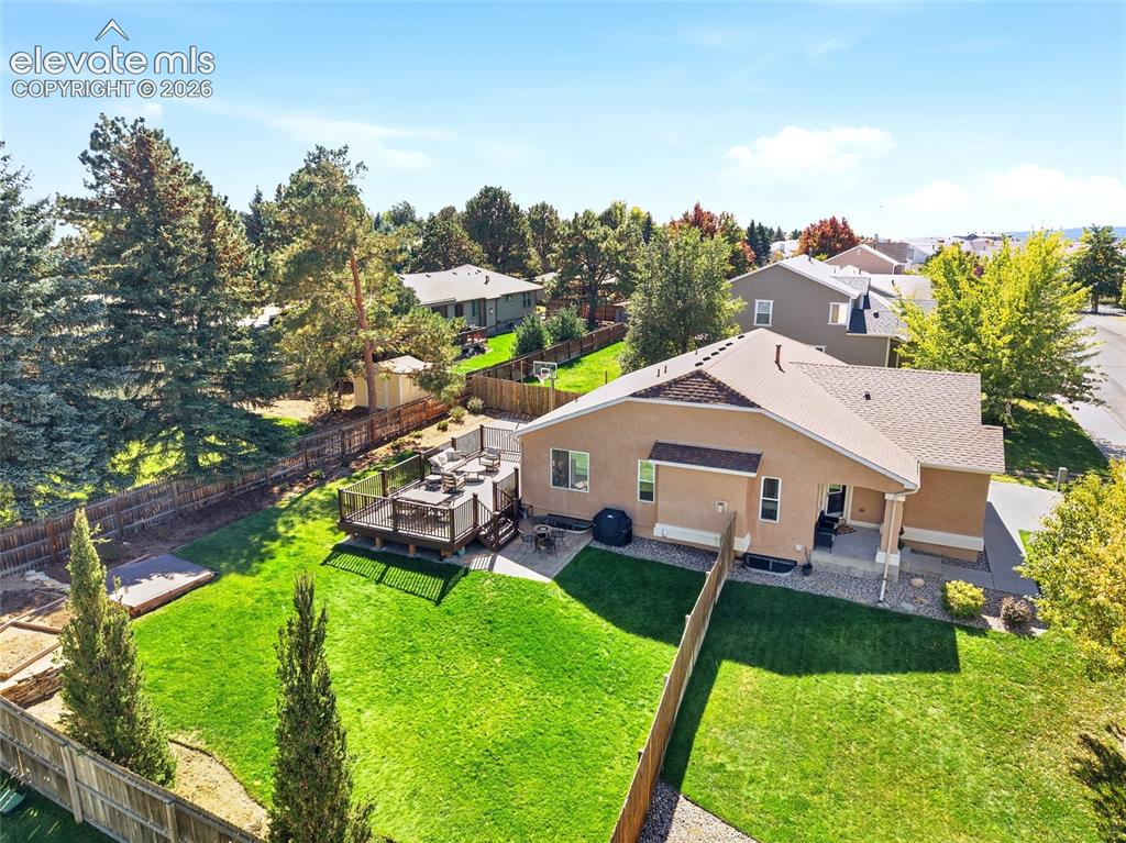 Image 44 of 50: Expansive backyard featuring a manicured lawn, a multi-level wood deck, a c