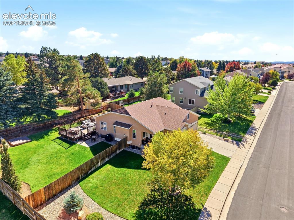 Image 46 of 50: Expansive backyard featuring a manicured lawn, a multi-level wood deck, and
