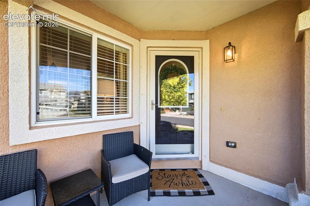 Image 5 of 50: Covered entry featuring a decorative glass storm door, an exterior wall sco