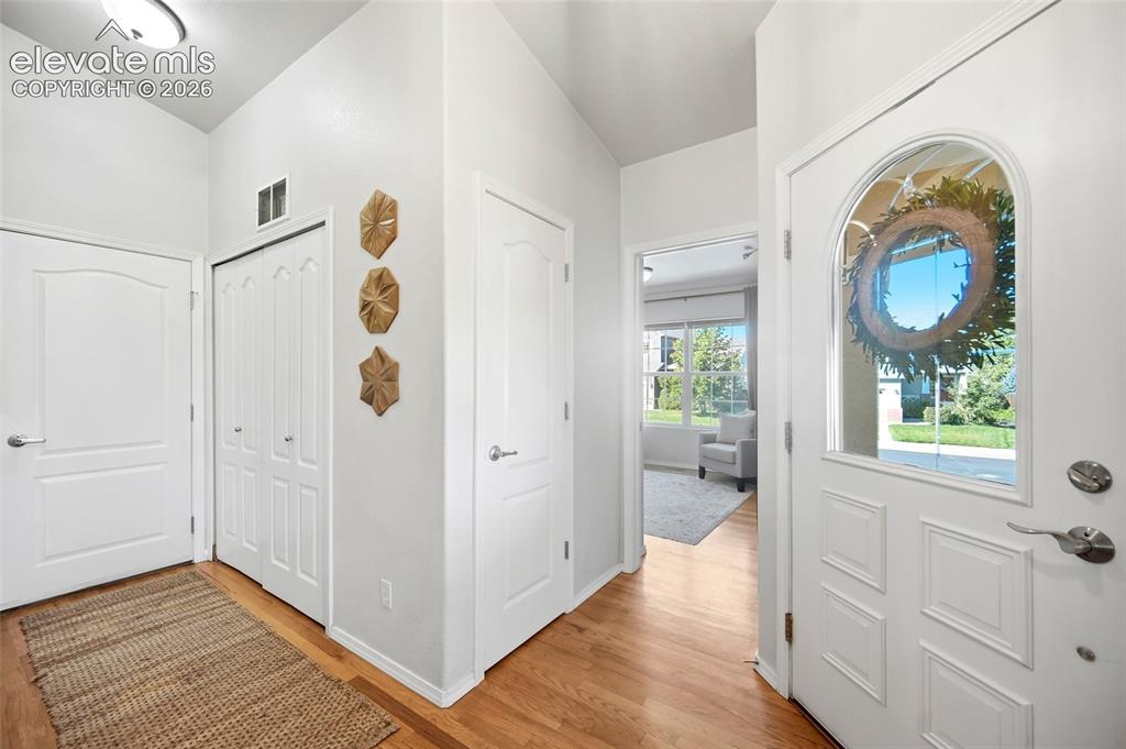 Image 6 of 50: Entryway featuring wood-finish flooring, a paneled door with an arched glas