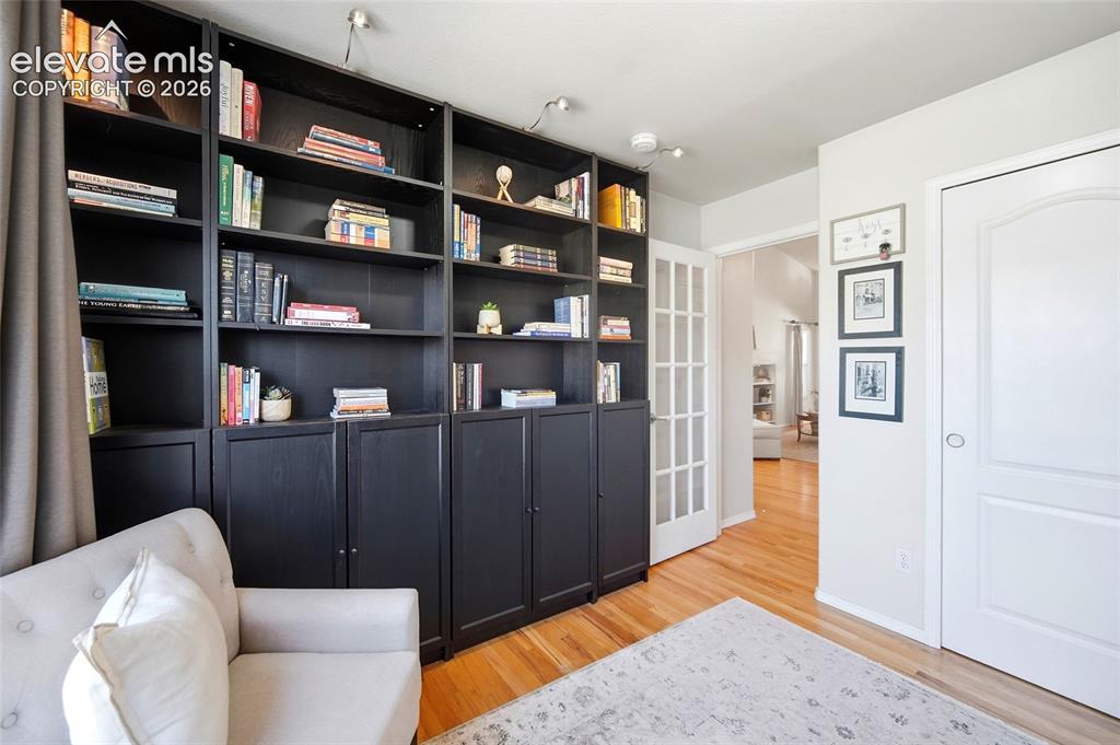 Image 8 of 50: Built-in shelving with lower cabinetry, track lighting, hardwood flooring,