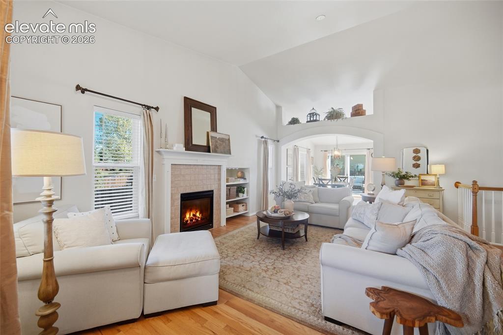 Image 9 of 50: Vaulted ceilings with an arched architectural opening, wood-finish flooring