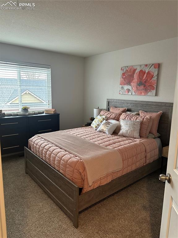 Image 26 of 38: Bedroom featuring a textured ceiling and carpet