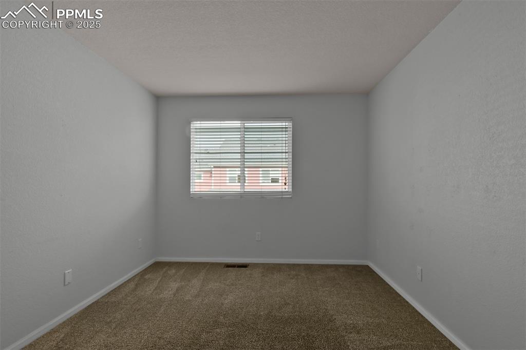 Image 30 of 38: Carpeted empty room featuring a textured wall and a textured ceiling