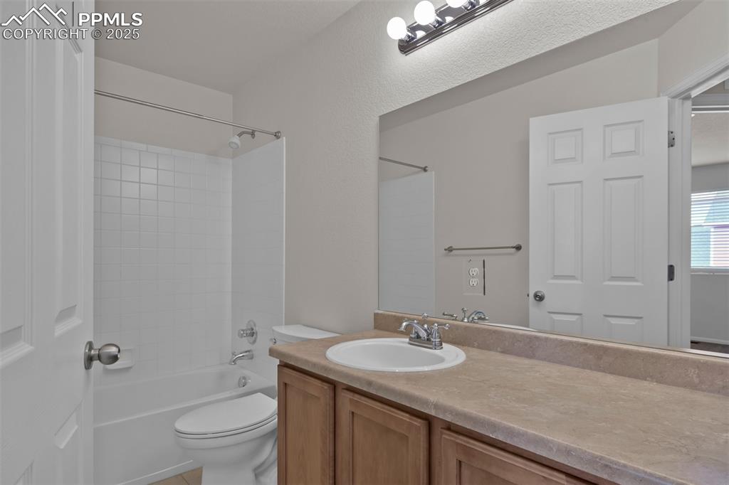 Image 31 of 38: Full bathroom with bathing tub / shower combination, vanity, and light tile