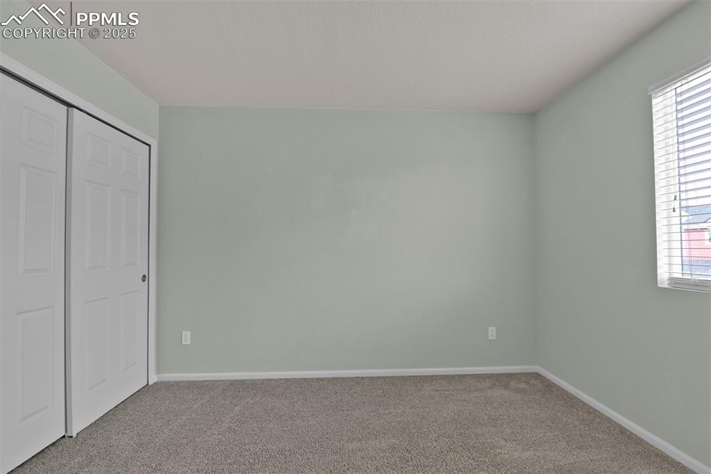 Image 34 of 38: Unfurnished bedroom with carpet, a closet, and multiple windows