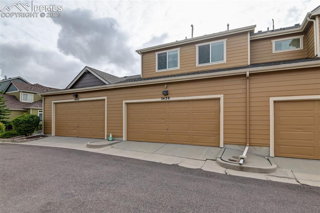 Image 37 of 38: View of rear of property with a garage.